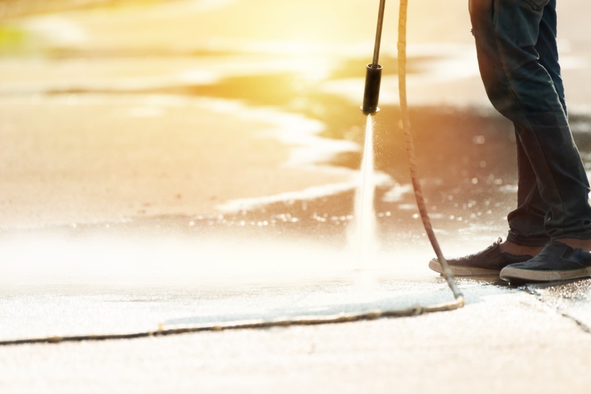 low-section-person-spraying-water-footpath.jpg